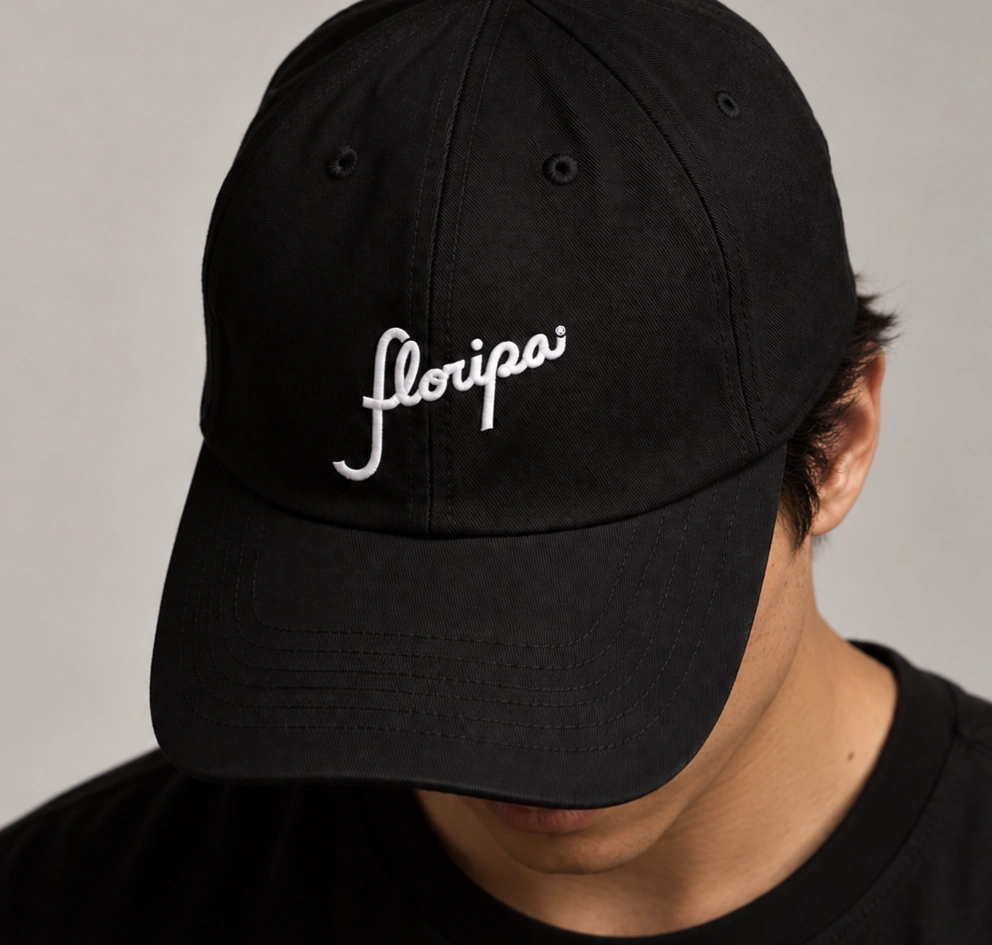 Black cap embroidered with the white Floripa script wordmark