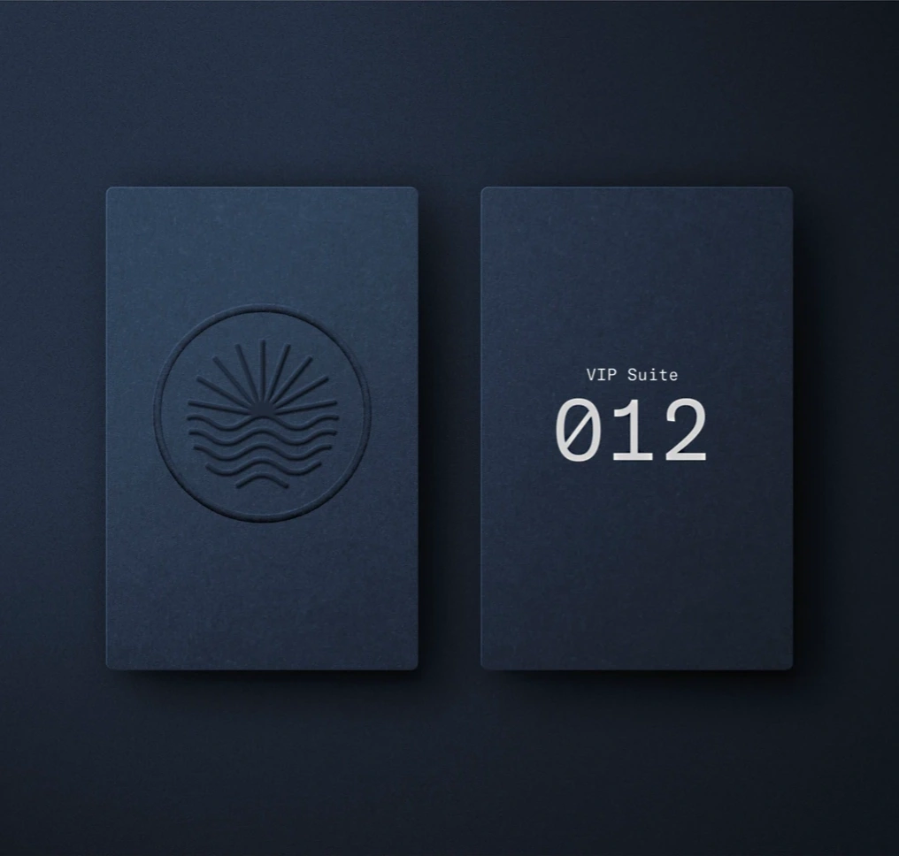 Infinite Jest sun-and-water emblem and VIP Suite 012 cards in dark blue