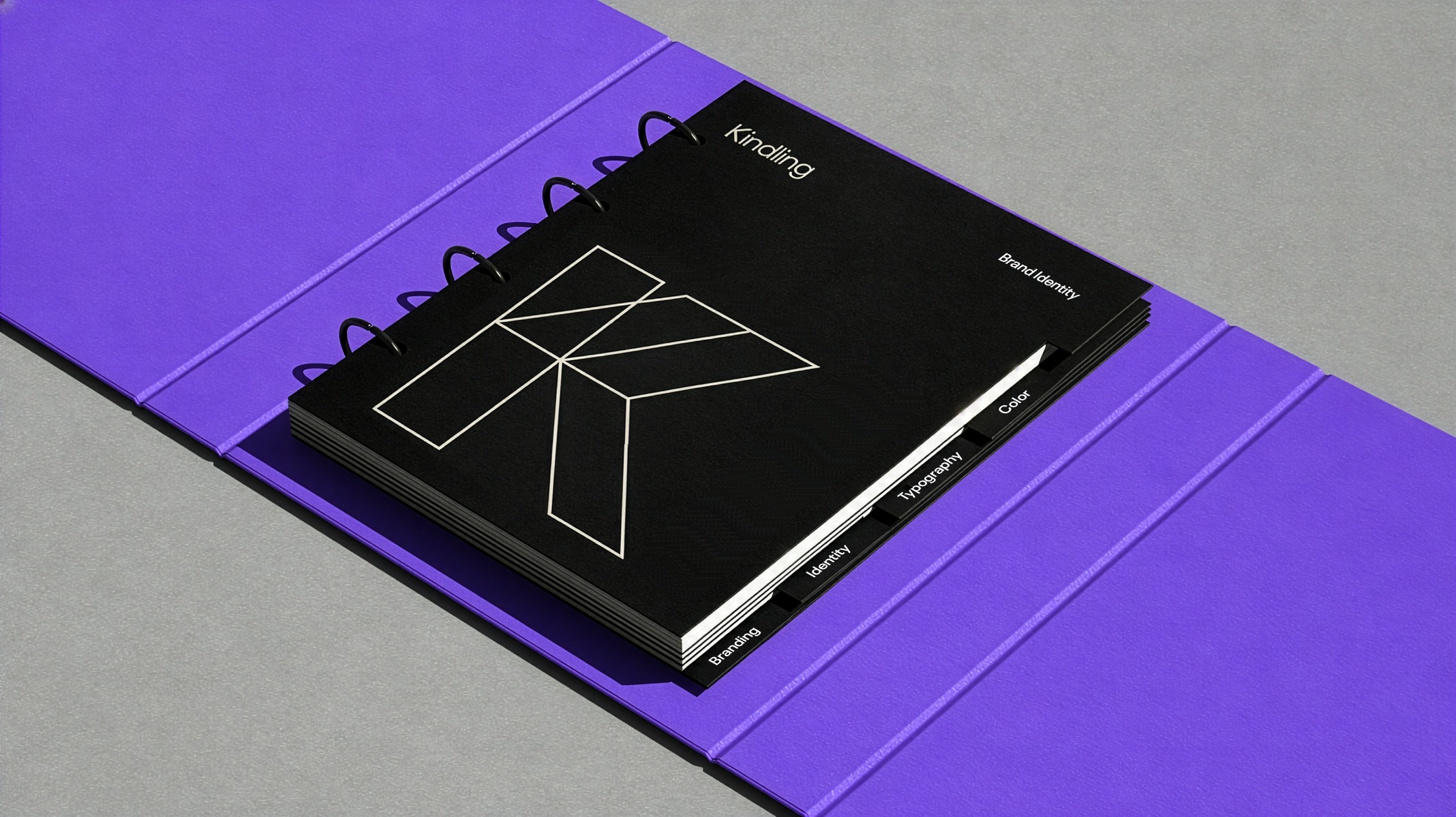 Kindling K monogram on a black spiral notebook with purple packaging