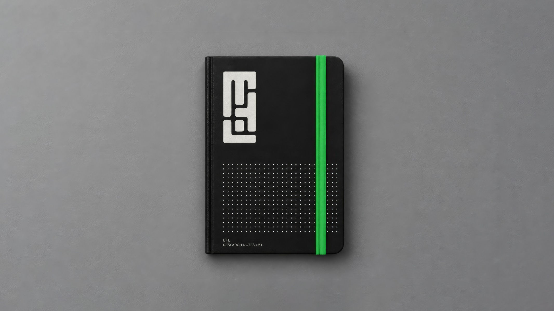 Black ETL notebook with a white monogram and green elastic band